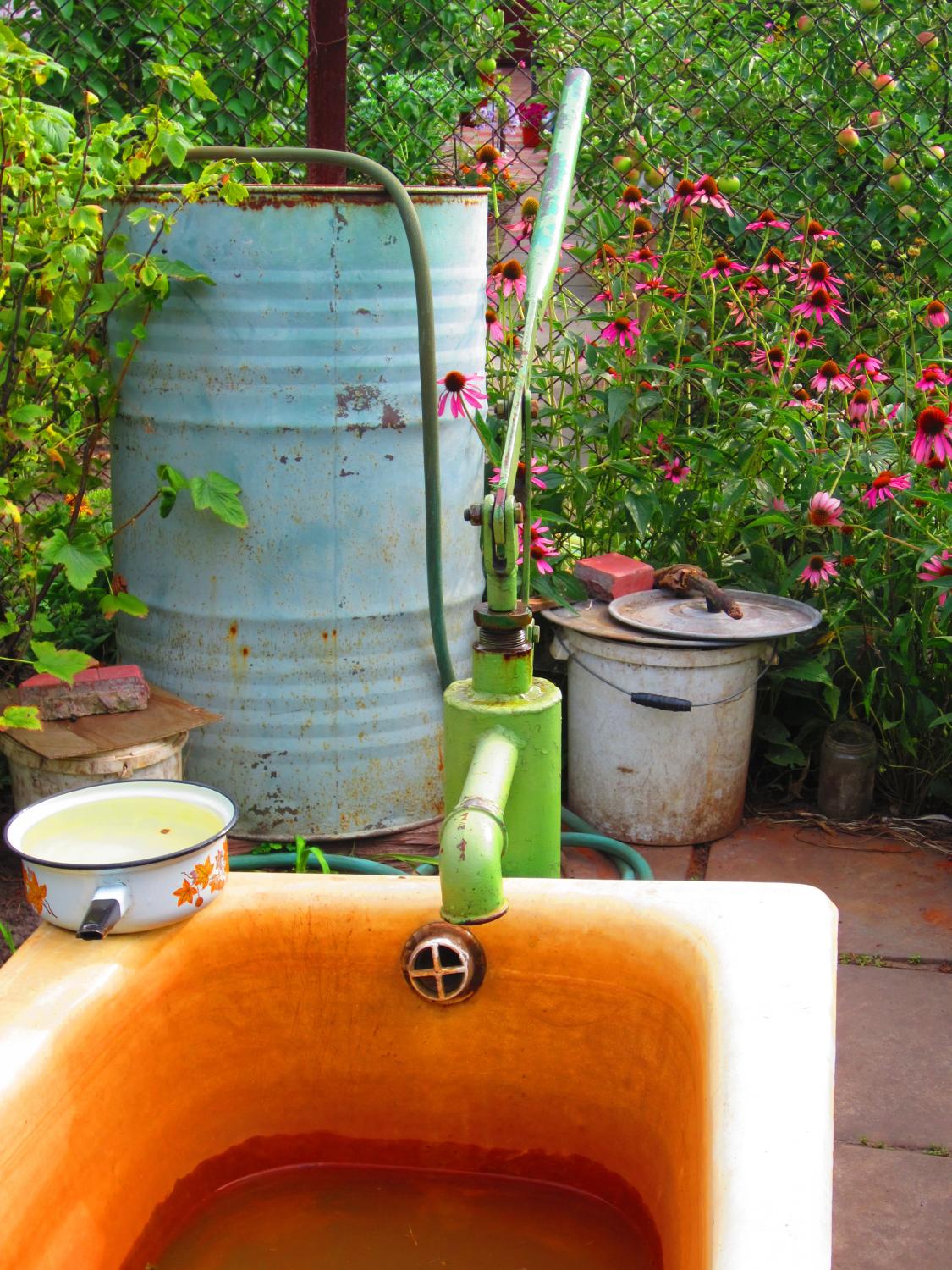 The well feeds excess water into an old bathtub they repurposed.