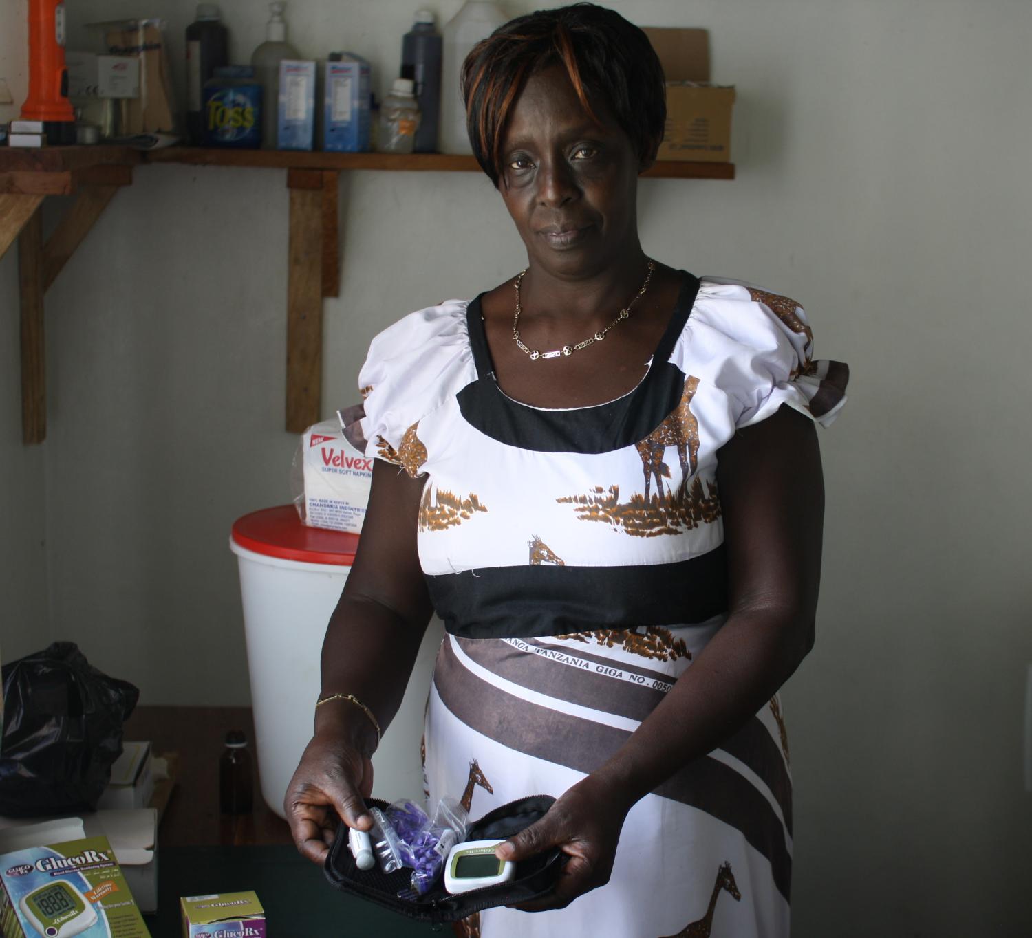Elizabeth with the glucometer that she bought with her Kiva loan.