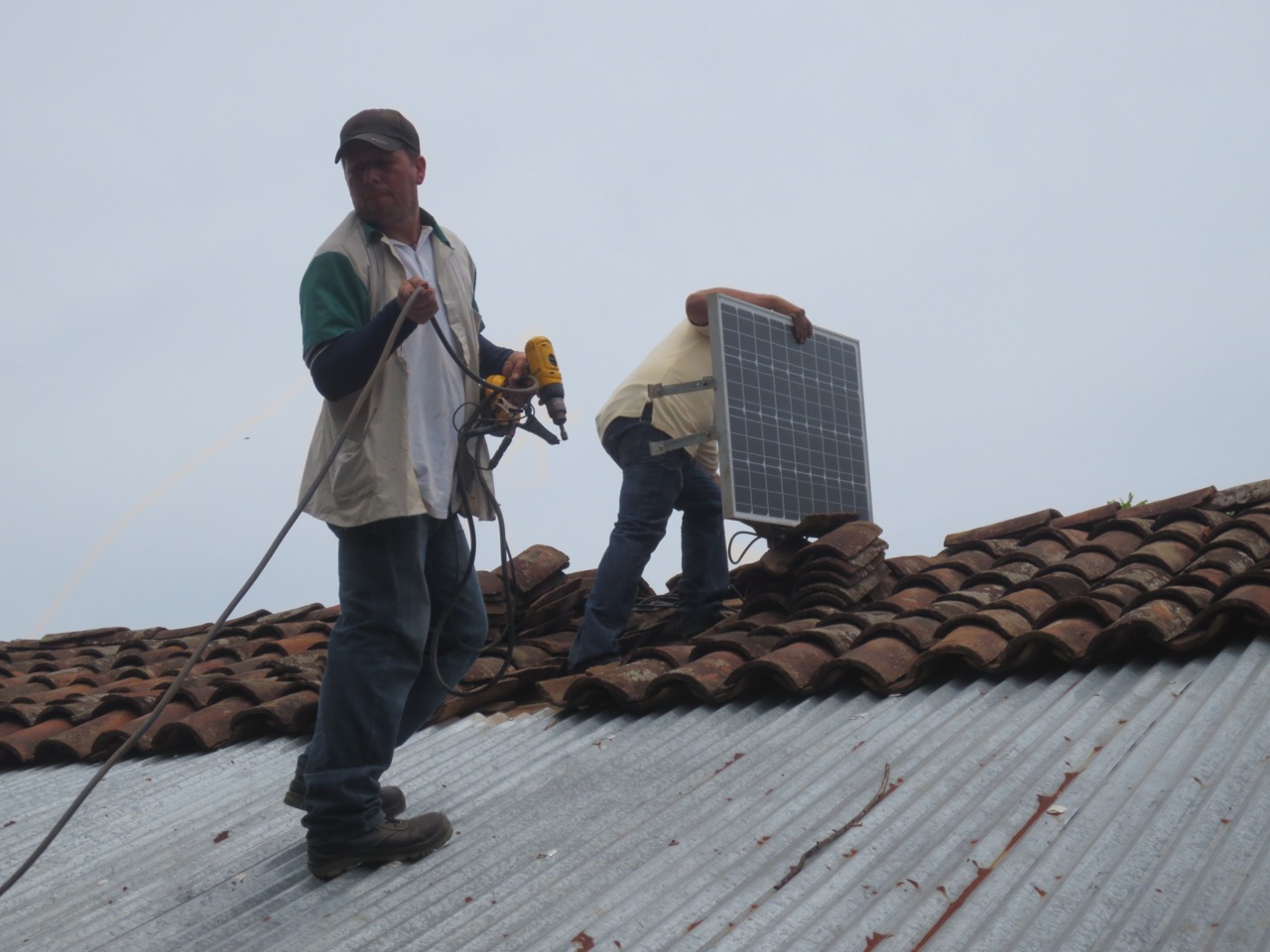 Two of Tecnosol’s technicians installing the solar panel on Zobeyda’s roof