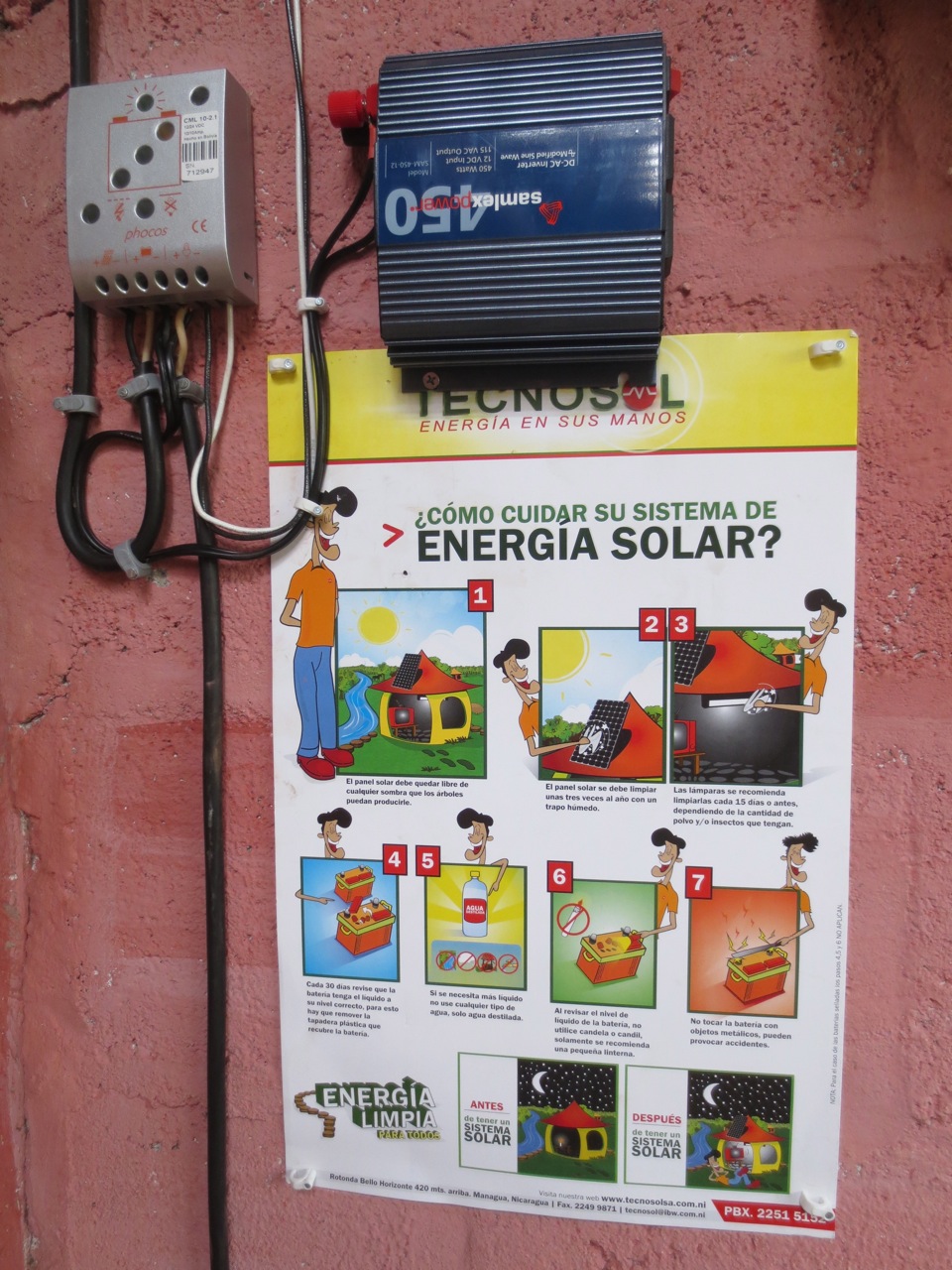 The installed solar charge controller (grey unit), DC-AC inverter (blue unit), and solar system maintenance instructions. The solar charge controller regulates and monitors the electric current that is added to and drawn from the battery. The DC-AC inverter converts DC energy from the battery (charged by the solar system) into AC current to enable the user to plug-in electronics (the plugs are on the right side of the pictured blue inverter).