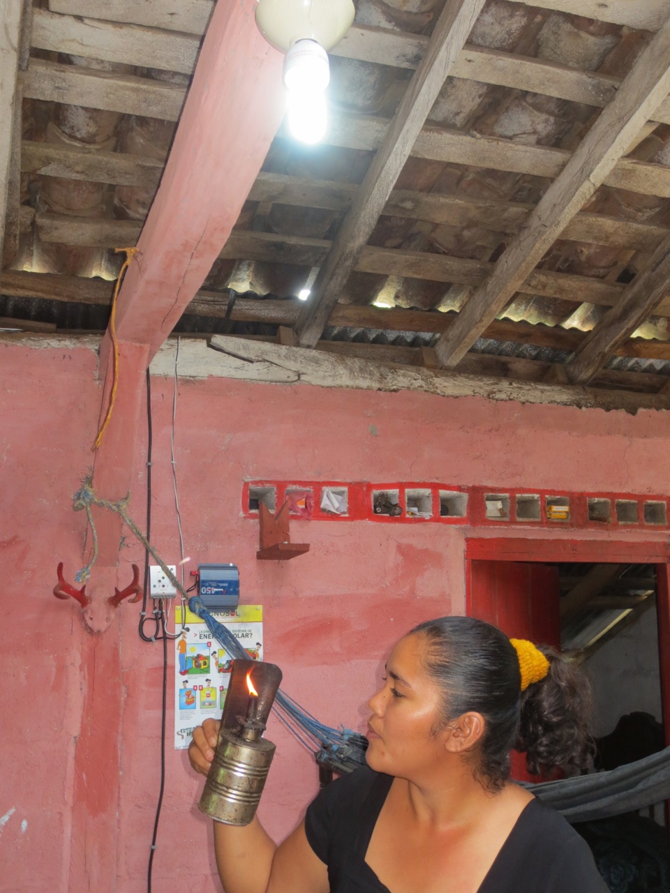 Zobeyda blowing out her kerosene lamp after her solar home system was installed and fully functional
