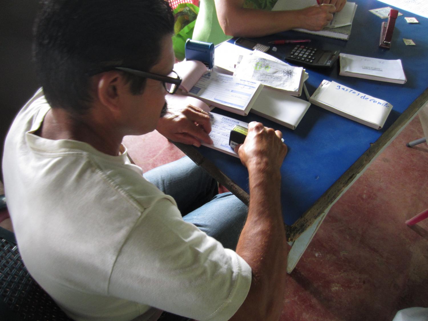 A lending committee in action, recording a loan payment.