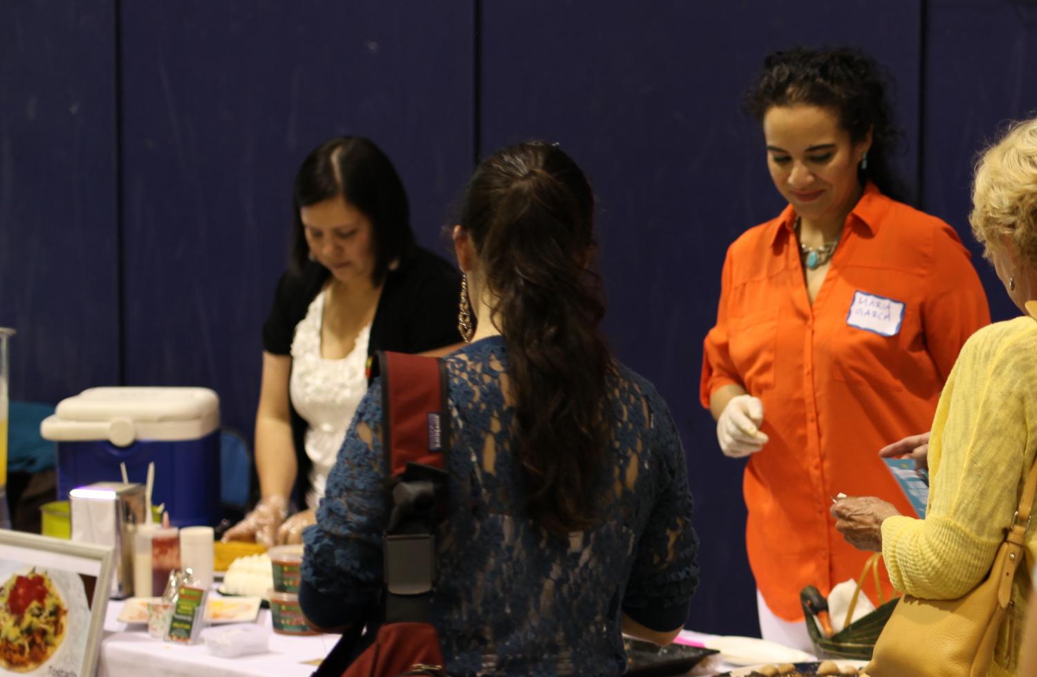 Maria Garcia takes a break from serving desserts to chat with event attendees