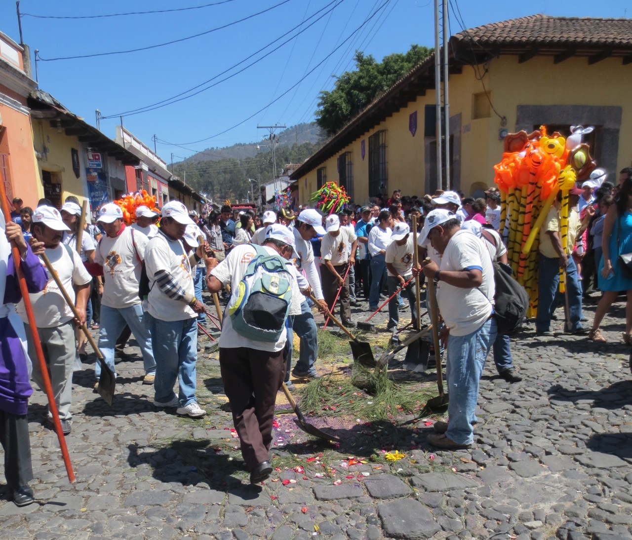 Workers cleaning up an alfombra after a processional