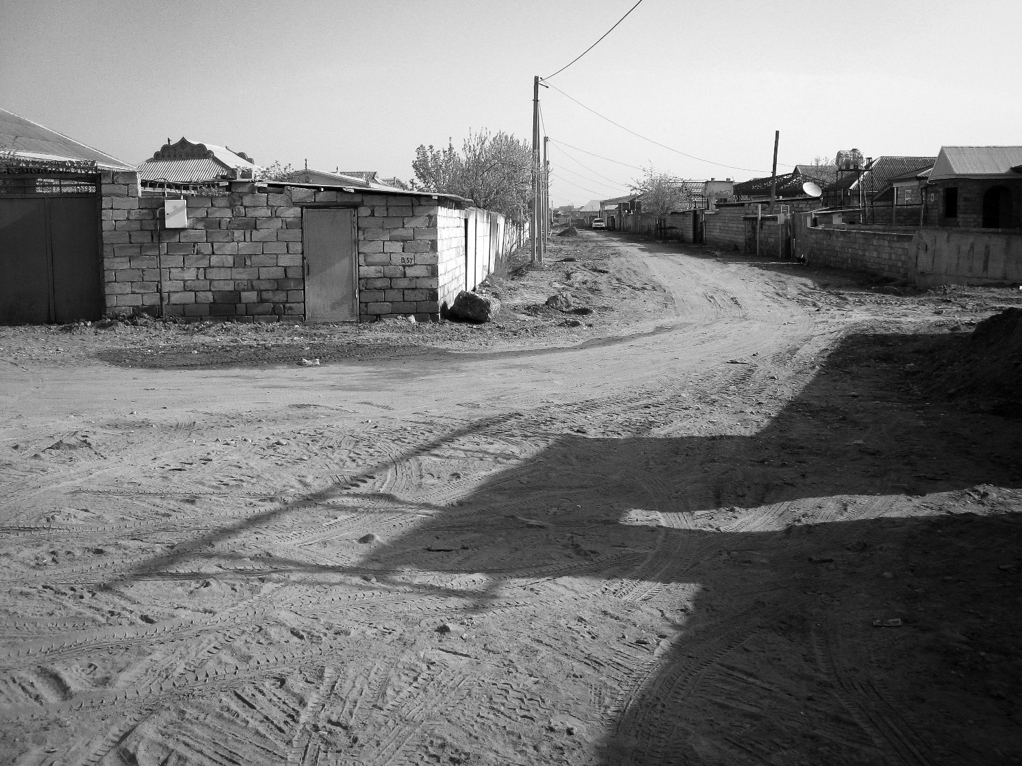 A typical residential backstreet. Dirt roads, closed off homes with metal doors.