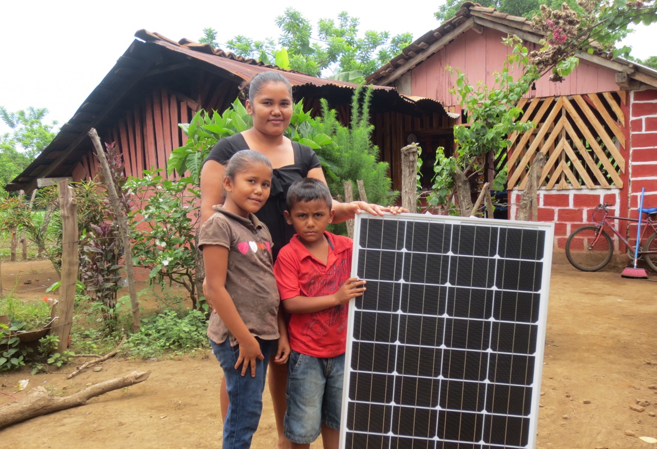 Zobeyda and her kids with their solar panel before the installation