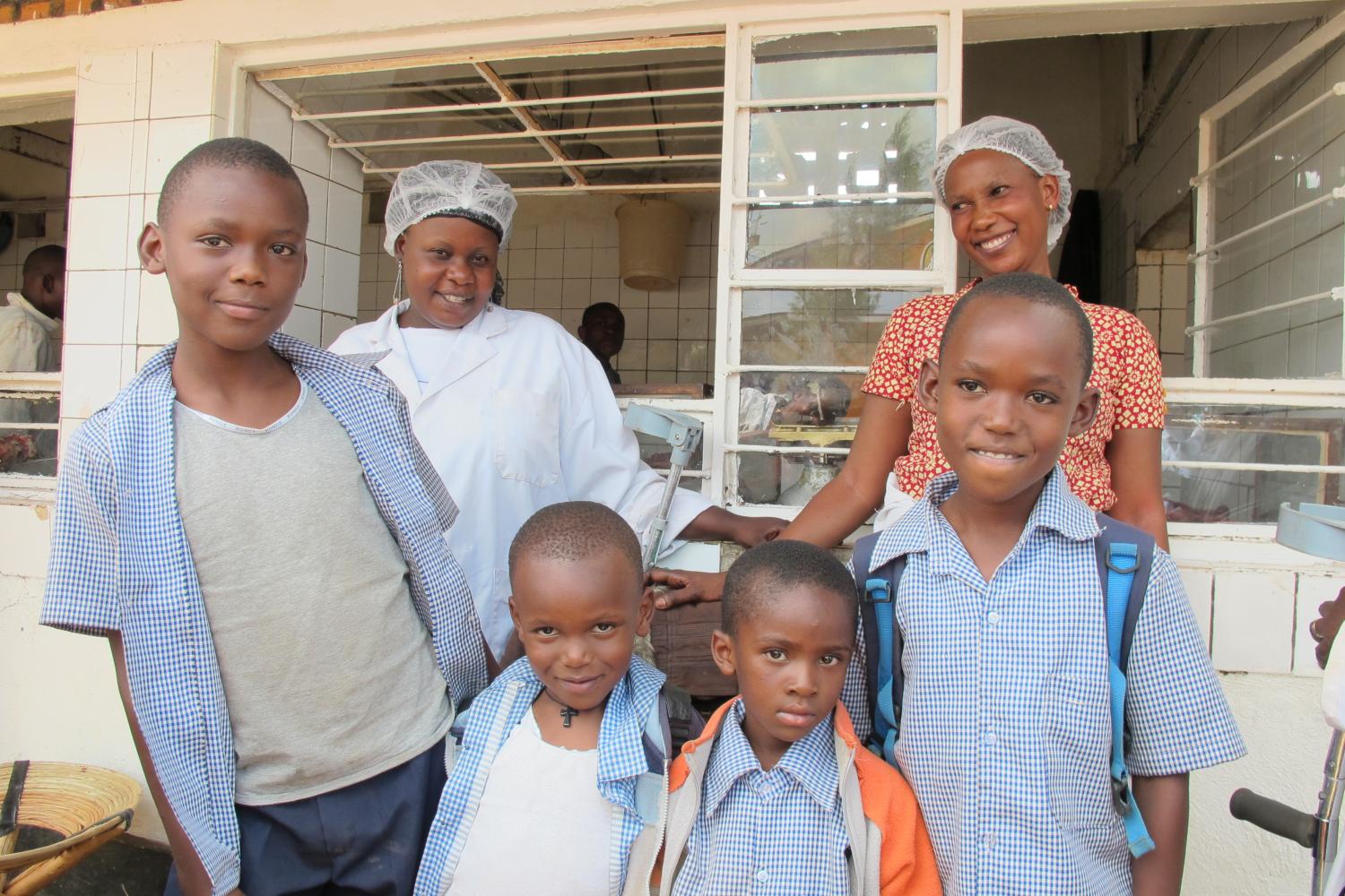 Epiphanie and Rehema with their sons outside their butcher shop
