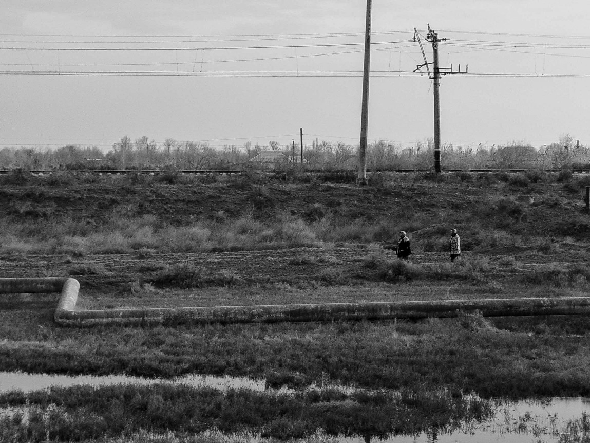 Beside the road to Sabirabad, women walk along pipeline carving up the hills.