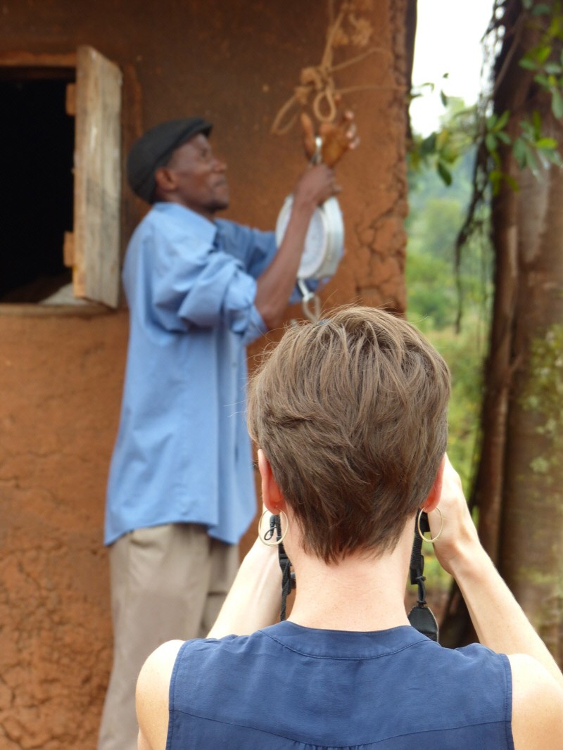 Liz filming Pascal with his weigh scale from Kiva's business-in-a-box
