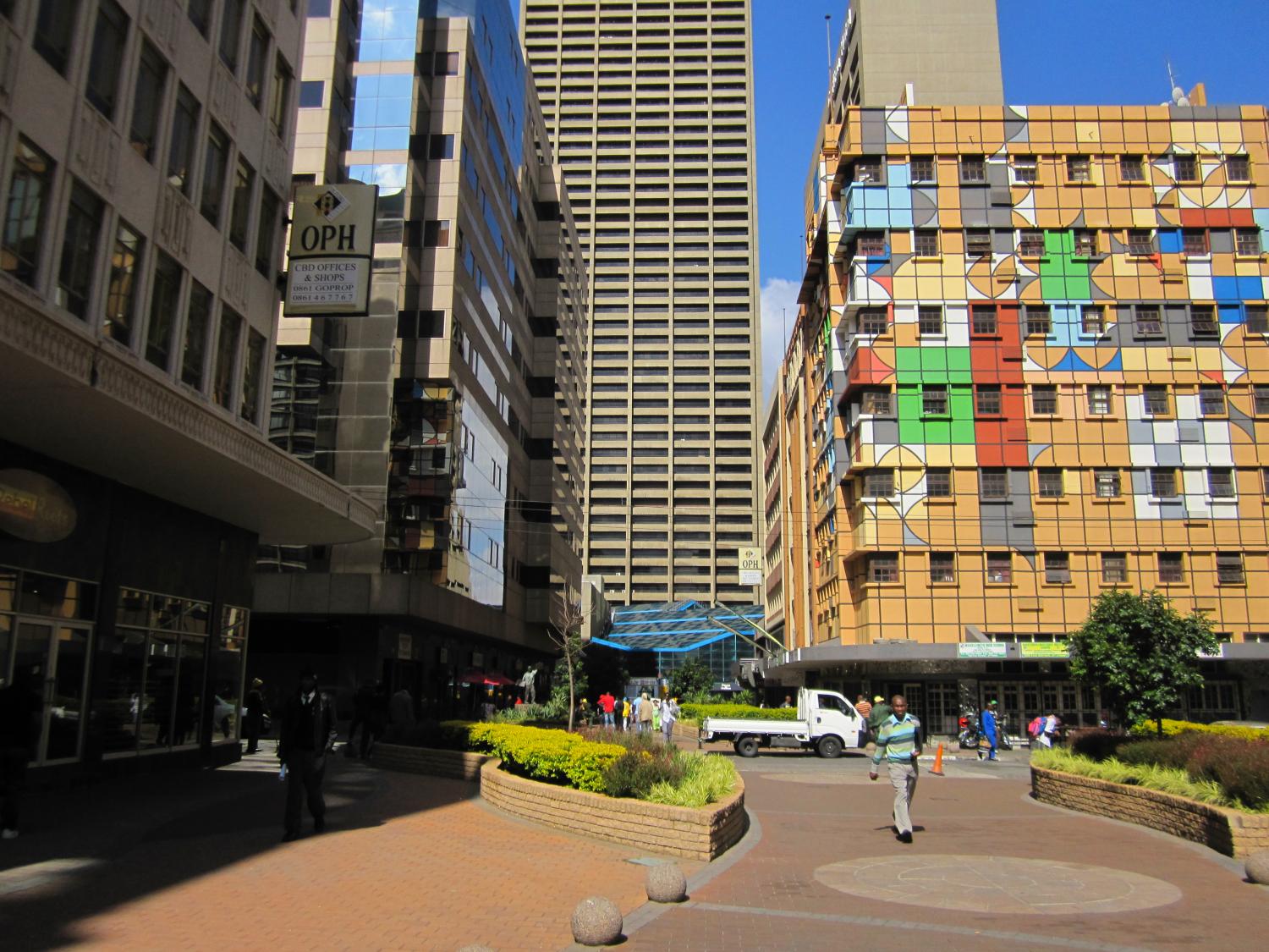 Main Street walkway in the central business district where the largest mining companies in South Africa are headquartered. You can see part of Carlton Center here, the tallest building in Africa.