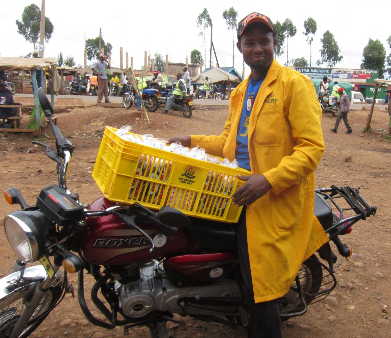 Eric on his piki piki that he uses to deliver bread he purchases from the bakery and resells to shops and schools.