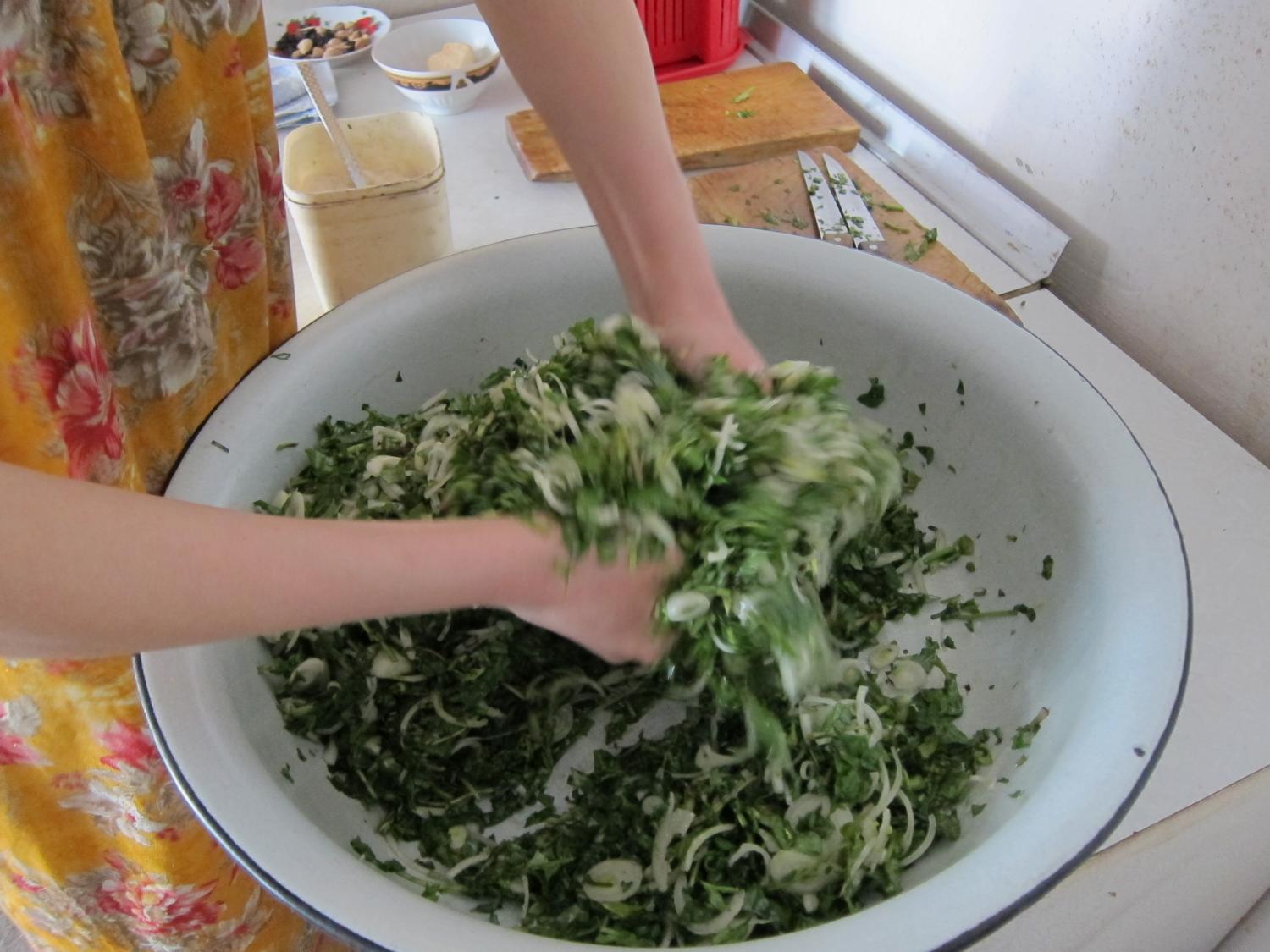 Tossing greens and onions, after adding warm oil