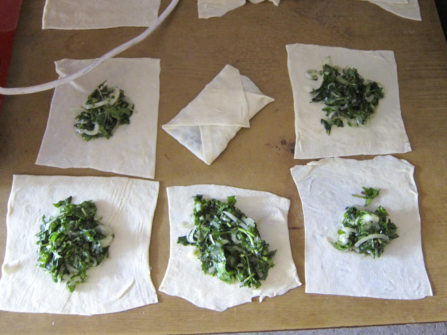 Fold the pastry corners toward the centre, enveloping the greens