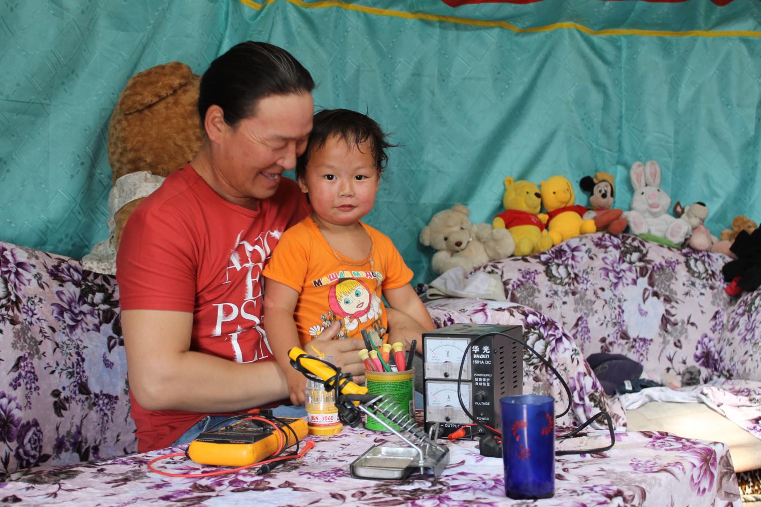 A father's love shines through in this photo! Meet Batjargal, pictured here with his young son. A single father living in Ulaanbaatar, Batjargal used his Kiva loan to purchase parts and equipment for his cell phone repair business. He hopes to grow his business as a way to support his family. Jane Imai, Mongolia