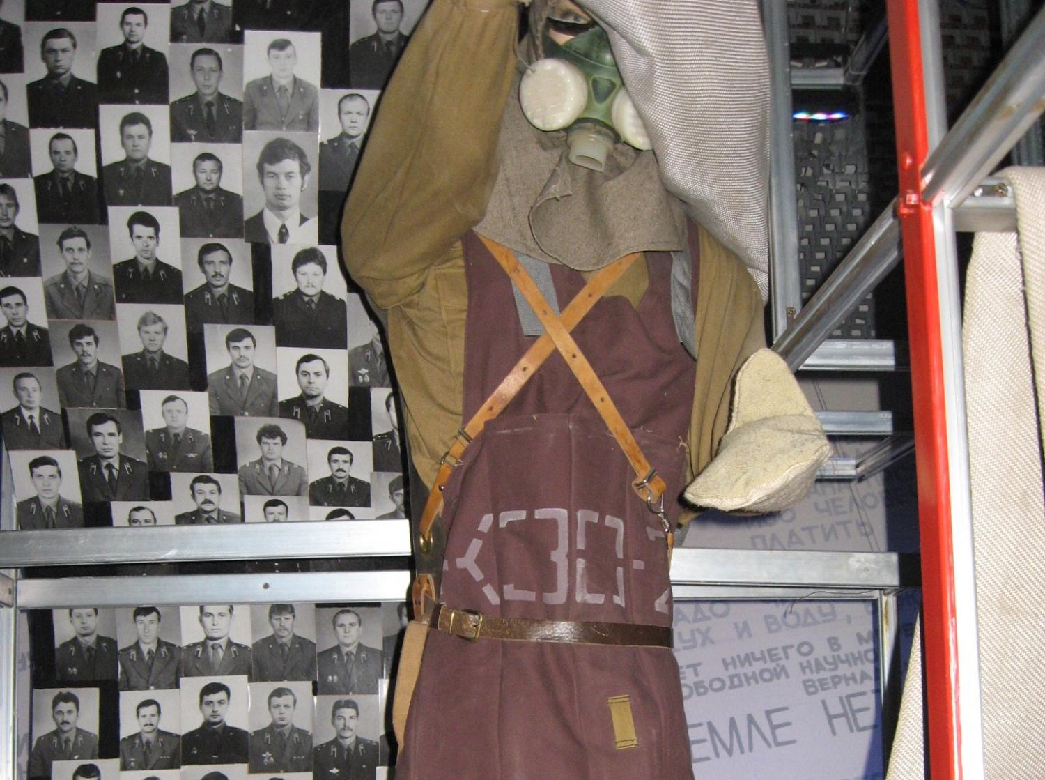 One of the suits worn by those who tried to help in the crisis, along with some of the photos of those who died.