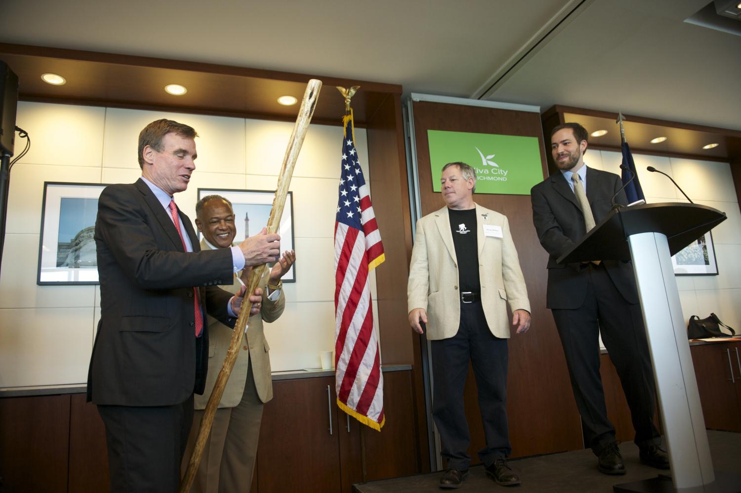 Steven McAlpin handing Senator Warner his own personalized walking stick.