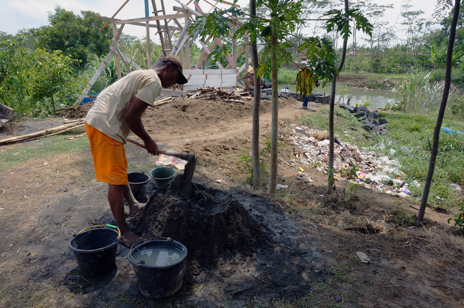 Worker mixing cement for the dock building. Photo credit: Yungkit
