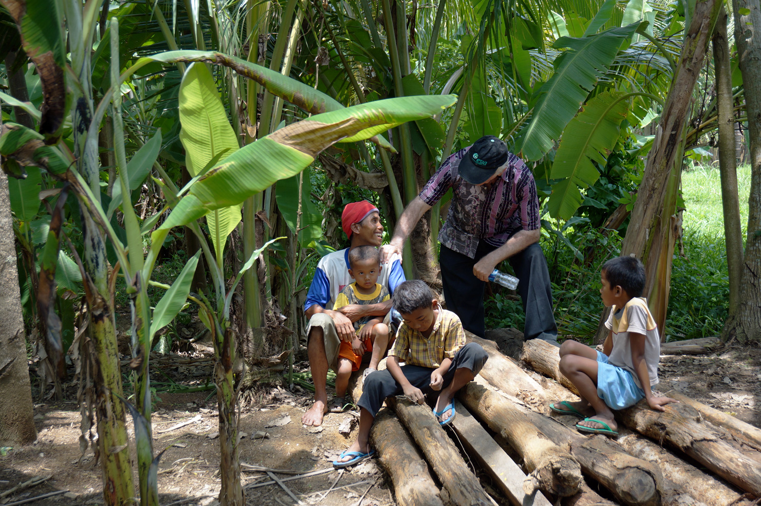 Kids waiting by the water pump to watch the water flow through. Photo credit: Yungkit