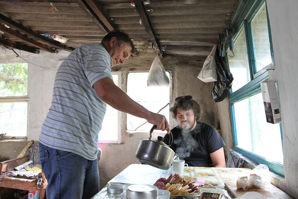 Sergei serves Grisha tea at his house during our visit