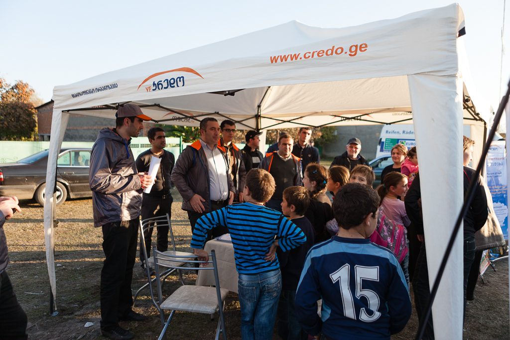 Kids crowd around the Credo tent at Village Day