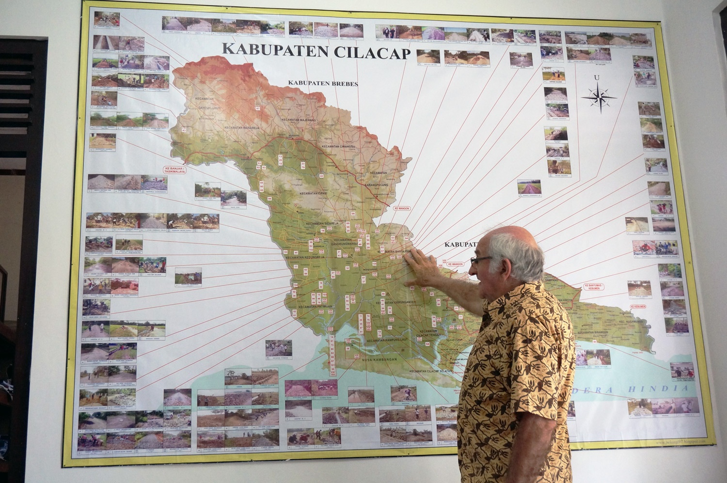 Father Charlie and the map of the Cilacap region showing the areas which YSBS has had projects. Photo credit: Yungkit