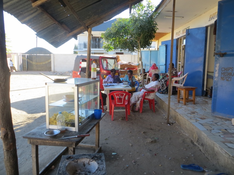 Group meeting near small shops with larges houses in the background