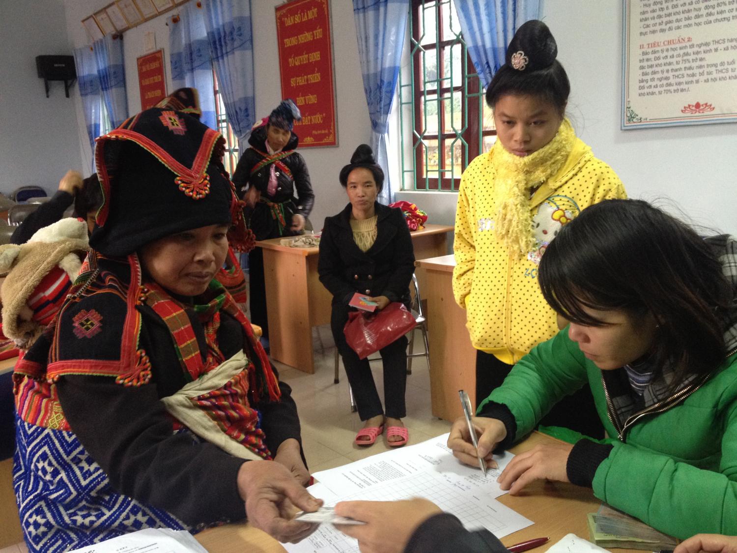 Mrs. Phuong - ACE accountant in green jacket collect signature before disbursement