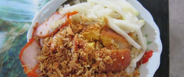 Xoi: sticky rice dish with barbecued pork, pickled cucumbers, a hard boiled egg, dried shallots, and drizzled with au jus. Love this for breakfast.